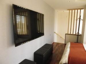 1 dormitorio con 1 cama y TV en la pared en Guest House Jinya - Vacation STAY 05308v, en Takayama