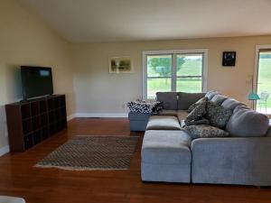 a living room with a couch and a flat screen tv at Secluded house on 60 acres close to Fall Creek Falls in Pikeville