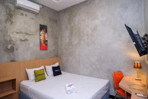 a small bedroom with a bed and a desk at Urbanview Hotel Syariah Artamara Tegal by RedDoorz in Tegal