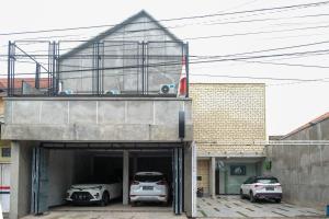 Un garaje con dos coches aparcados dentro. en Urbanview Hotel Syariah Artamara Tegal by RedDoorz, en Tegal