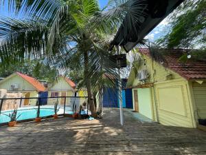 een palmboom naast een huis met een zwembad bij MAH Resort by Cocotel in Manilla