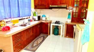 a kitchen with wooden cabinets and a sink and a stove at D'Serina Homestay-3 bedroom 6 bed & free parking in Sungai Petani