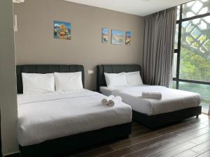 a bedroom with two beds and a window at Hotel Mutiara in Gua Musang