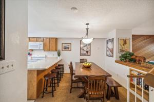 a kitchen and dining room with a wooden table and chairs at Winter Point 20 in Breckenridge