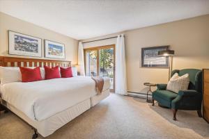 a bedroom with a bed and a chair and a window at Winter Point 20 in Breckenridge