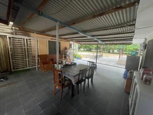- une cuisine et une salle à manger avec une table et des chaises dans l'établissement Ikhlas Roomstay, à Kampong Alor Gajah