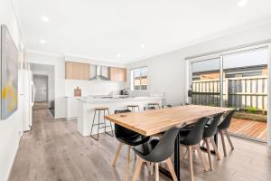 a kitchen and dining room with a wooden table and chairs at The Seas at Phillip Island in Cowes