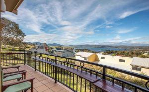 a balcony with benches and a view of the water at Dromaius 6 in Jindabyne