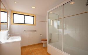 a bathroom with a shower and a sink and a toilet at Dromaius 6 in Jindabyne