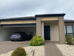 um carro estacionado em frente a uma garagem em 4 Beds-Whole House-Black Knight Way-Kuranjang-Less than 30 minutes From Melbourne international airport em Melton