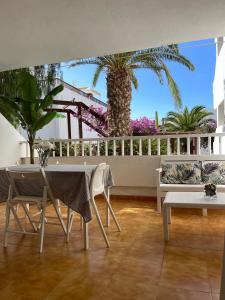 a room with a table and chairs and a palm tree at Teguisol 258, Apt. with terrace, near the beach in Costa Teguise