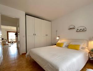 a bedroom with a large white bed with yellow pillows at Teguisol 258, Apt. with terrace, near the beach in Costa Teguise