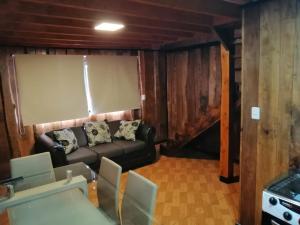 a living room with a couch and a table at CABAÑAS _EL NATIVO in Choshuenco