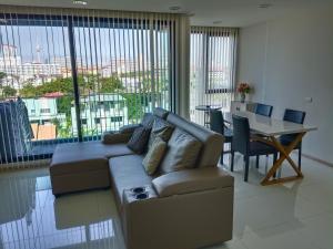 a living room with a couch and a table at Acqua Condominium Jomtien in Jomtien Beach