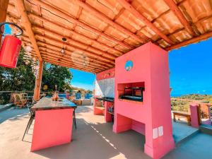 a pink kitchen with a stove on a deck at Vila Real Apartamentos in Itacaré