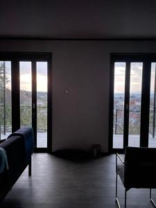 a bedroom with large windows with a view of a city at Bianca55 in Tannowa