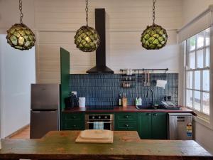 kuchnia z zielonymi szafkami i lodówką w obiekcie Miners Cottage Beechworth w mieście Beechworth