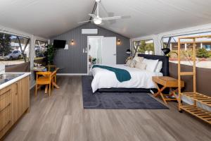 a master bedroom with a bed and a kitchen at BIG4 River Myall Holiday Resort in Bulahdelah