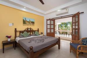 a bedroom with a large bed and a chair at The Ultimate Staycation Goa - 10BHK in Calangute
