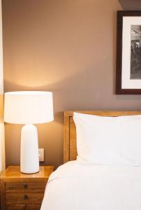 a bedroom with a bed and a lamp on a nightstand at Banksia by the Bay in Emu Point
