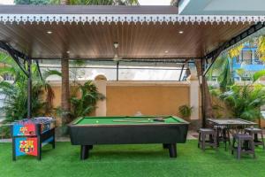 a pool table in a covered area with a table and chairs at The Ultimate Staycation Goa - 10BHK in Calangute