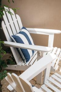 a white rocking chair with a blue pillow on it at Banksia by the Bay in Emu Point