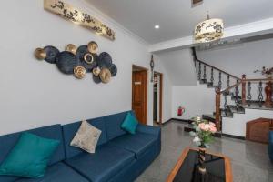 a living room with a blue couch and a table at The Ultimate Staycation Goa - 10BHK in Calangute