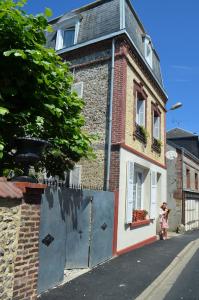 una casa de ladrillo con una puerta azul delante de ella en Chambres d'hôtes Villa l'espérance, en Étretat