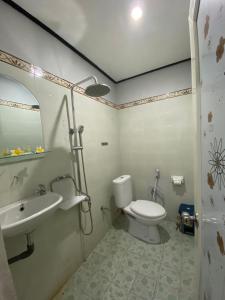 a bathroom with a toilet and a sink at Guest House Pondok Puspa Ayu in Kuta