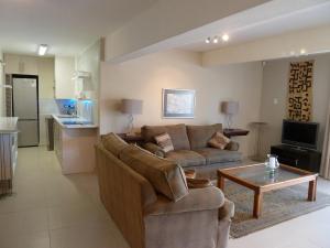a living room with a couch and a table at Agape Apartments in Somerset West