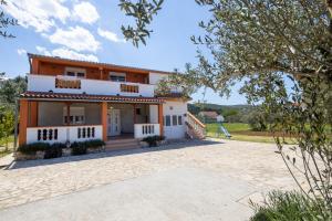an image of a house with a playground at Apartments Den - 100 m from sea in Pašman