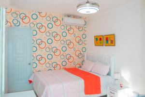 ein Schlafzimmer mit einem Bett mit einer farbenfrohen Wand in der Unterkunft D´ Yoko Village´s in Pedernales