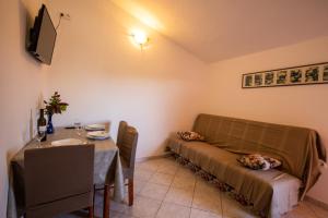 a small room with a bed and a table and a table and a tableablish at Apartments Den - 100 m from sea in Pašman