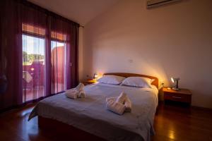 a bedroom with a bed with two towels on it at Apartments Den - 100 m from sea in Pašman