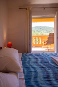 a bedroom with a bed and a view of a patio at Apartments Den - 100 m from sea in Pašman