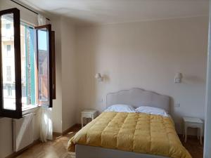 een slaapkamer met een bed met een geel dekbed en een raam bij Appartamento tra San Pietro e Castel S.Angelo in Rome