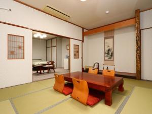 ein Esszimmer mit einem Holztisch und Stühlen in der Unterkunft Seaside Hotel Kujukuri in Sanmu