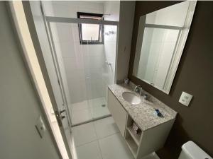 La salle de bains est pourvue d'une douche, d'un lavabo et d'un miroir. dans l'établissement 67 New studio in great location! Fast WI-FI, balcony, à São Paulo