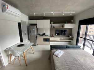 Habitación con cama, mesa y cocina. en 67 New studio in great location! Fast WI-FI, balcony, en São Paulo