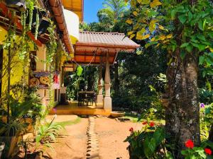 a patio with a gazebo in a garden at Sudumal Cottage in Ella
