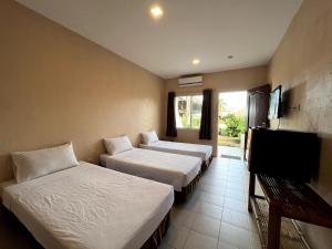a hotel room with two beds and a flat screen tv at Ocean Bay Beach Resort in Dalaguete