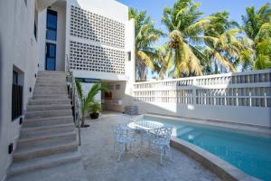 a patio with a table and chairs next to a pool at La Casona de Sisal Hotel in Sisal