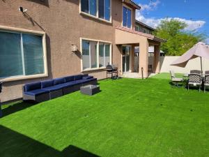 a lawn with a blue couch and chairs in front of a house at 5 bed 3.5 baths in Las Vegas