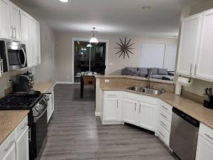 a kitchen with white cabinets and a living room at 5 bed 3.5 baths in Las Vegas