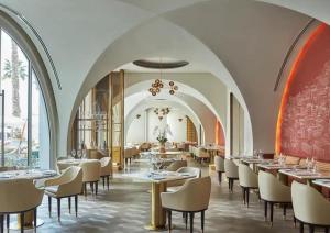 un comedor con mesas, sillas y ventanas en Five Palm Residences, en Dubái