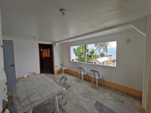 une chambre avec une table, des chaises et une fenêtre dans l'établissement Ocean Bay Beach Resort, à Dalaguete