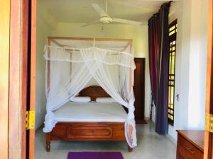 una camera con letto a baldacchino di Sudumal Cottage a Ella