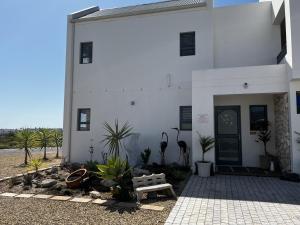 a white building with a bench in front of it at Clam Lagoon in Langebaan