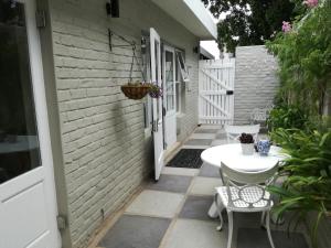 a patio with a table and chairs and a building at At Leisure in Worcester