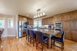 una cocina con armarios de madera y una gran isla con sillas en Northbay, en Pagosa Springs